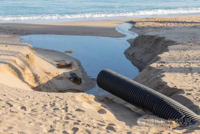 工业废水管道将液体工业废物排放到城市海滩一个城市海滩.